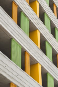 Modern building facade with vivid green and yellow panels creating a striking geometric pattern.