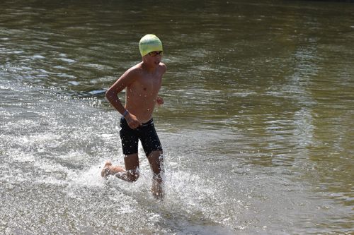 Free Energetic young athlete emerges from water during a triathlon in Jánd, Hungary, showcasing endurance and determination. Stock Photo