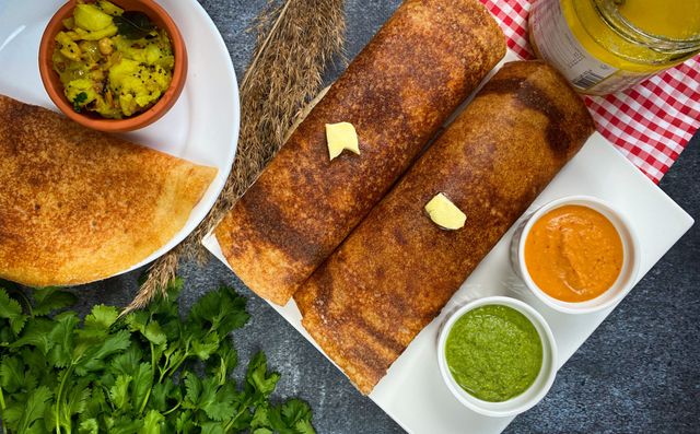 Crispy dosas with vibrant chutneys and spiced potatoes, offering a taste of Indian cuisine.