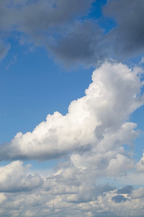 Free Powerful clouds against a vibrant blue sky, capturing a serene and dynamic atmosphere. Stock Photo