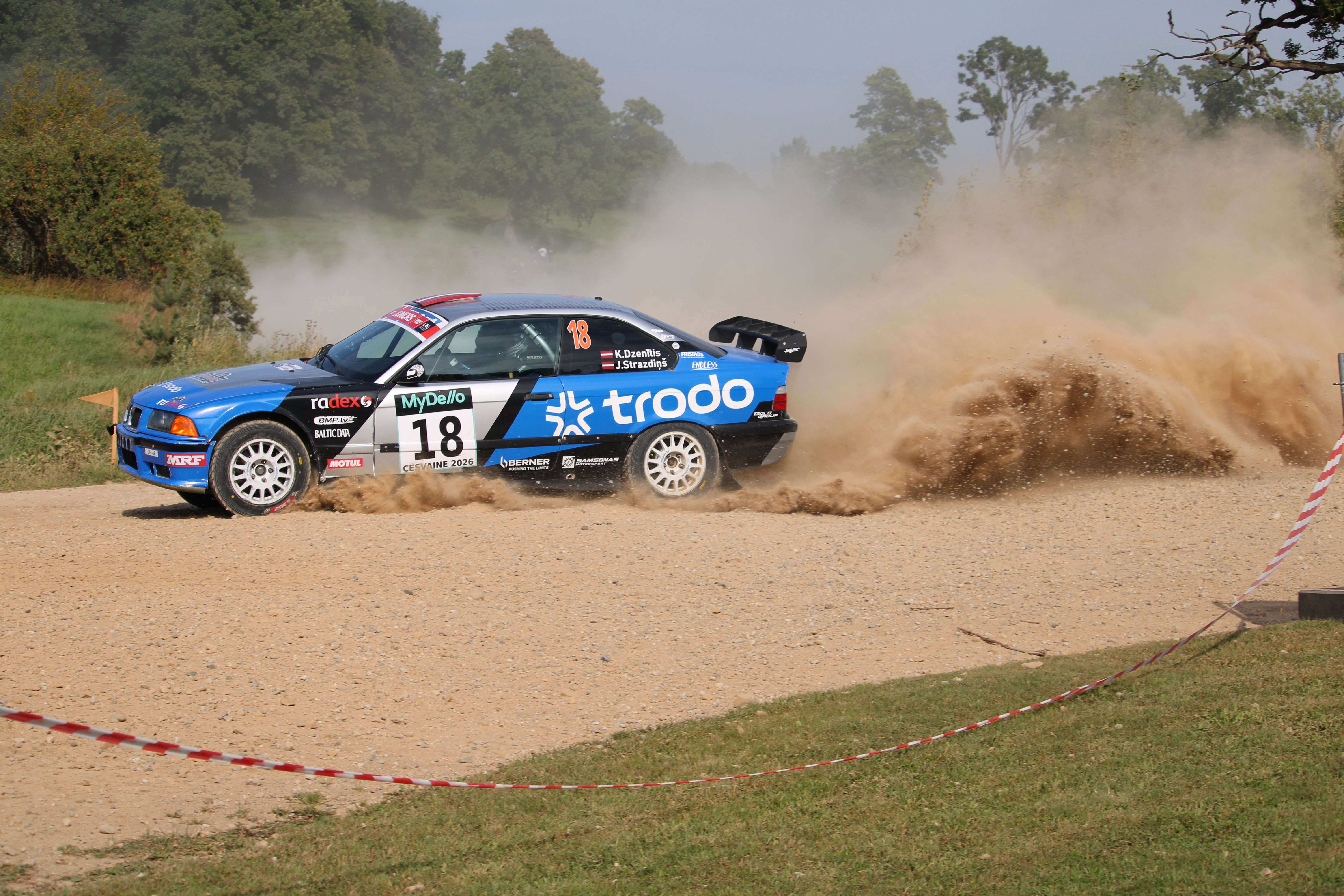 A rally car speeds through a dirt track in Cesvaine, Latvia, creating an exhilarating cloud of dust.