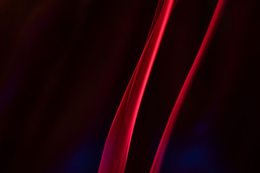 Vibrant red lines creating an abstract composition on a dark background, emitting a mysterious and modern feel.