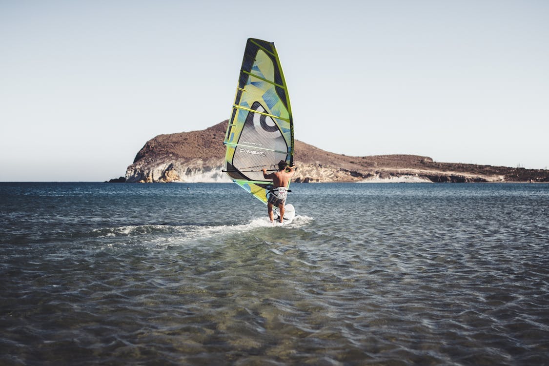 Man Riding Green and Black Boat on Water