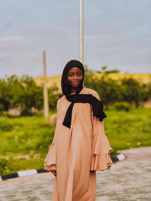 Free Elegant woman in hijab poses outdoors with a serene background. Stock Photo