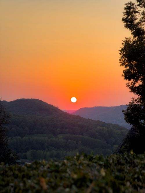 Free Beautiful sunset view with vibrant sky over lush rolling hills, capturing serene nature. Stock Photo
