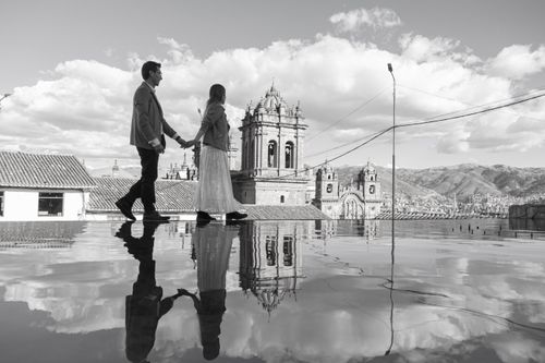 Free Romantic walk in Cusco, Peru, with reflections of historic architecture and mountainous backdrop. Stock Photo