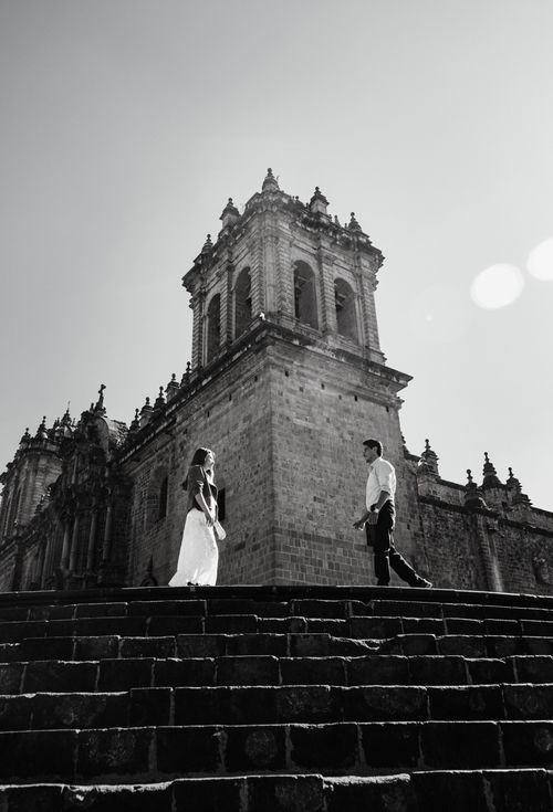 Free Black and white image of a couple in front of an old cathedral Stock Photo
