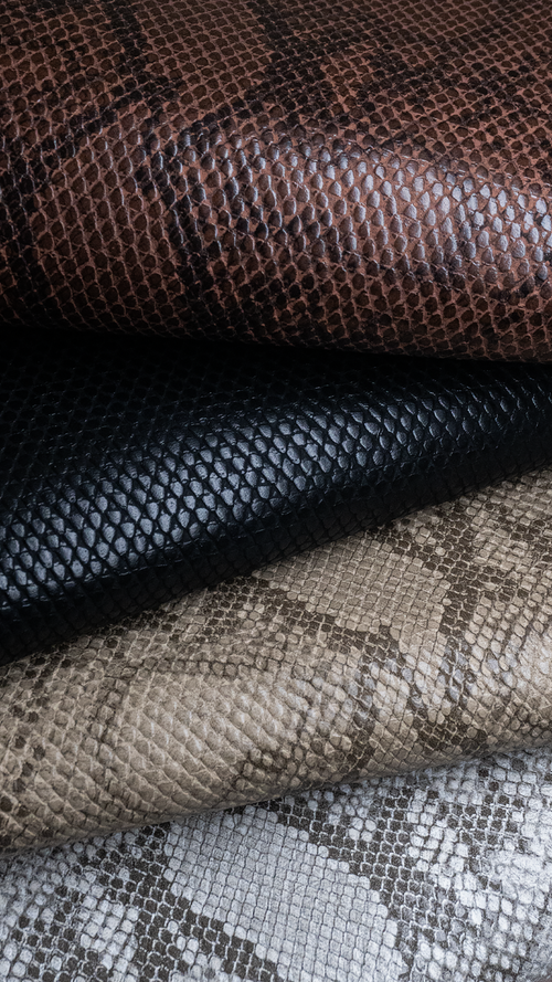 Free A detailed view of various snake print leather fabrics showcasing texture and color variety. Stock Photo
