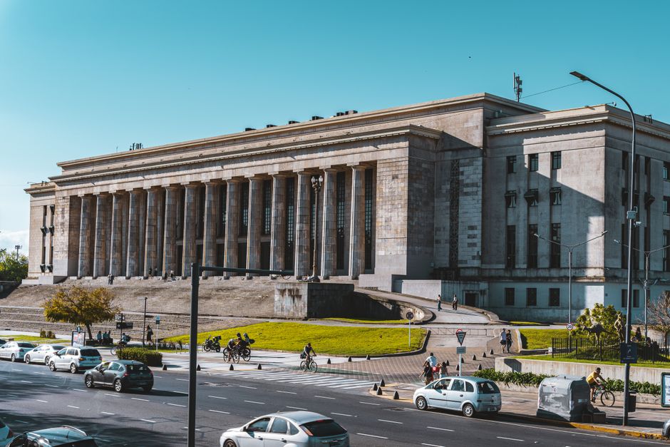 Vista del emblemático edificio de la Facultad de Derecho de Buenos Aires, Argentina, con tráfico y peatones a la vista.