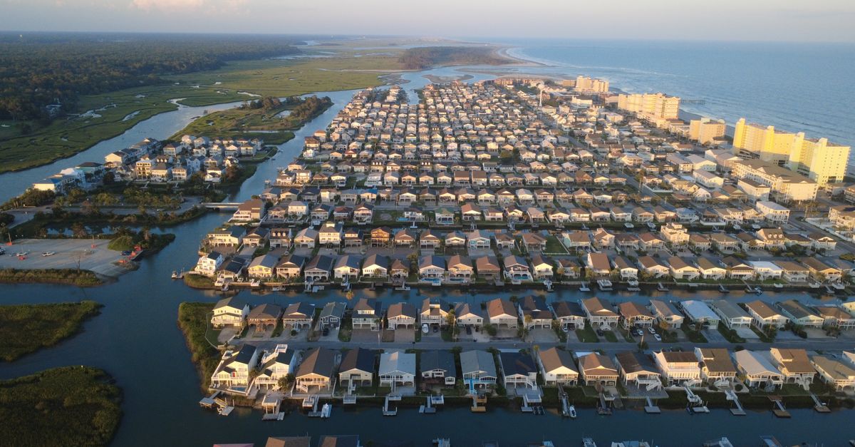 Aerial view of Cherry Grove in North Myrtle Beach, showcasing coastal homes and waterways at sunset.