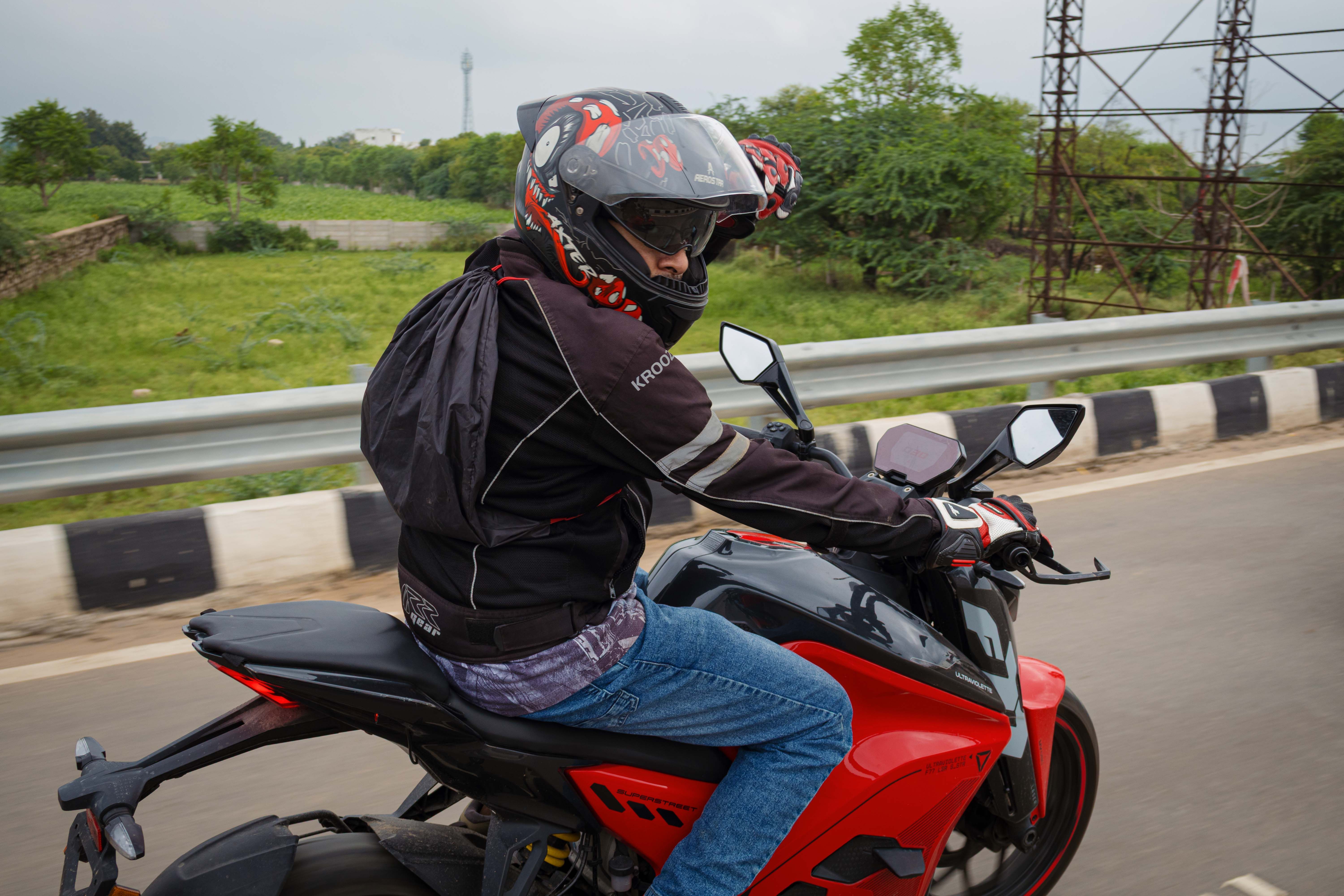 Person riding an electric motorcycle on a road in Jaipur, India.