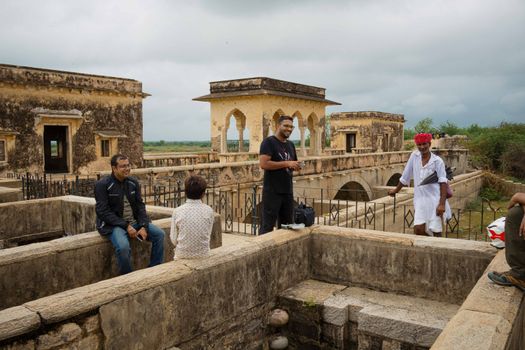 Tourists engaging with a local guide at an ancient site in Jaipur, Rajasthan.
