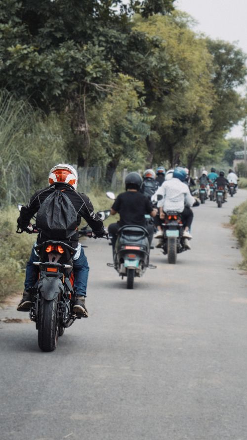 Free A group of bikers rides down a rural road in Jaipur, Rajasthan, India, showcasing camaraderie and adventure. Stock Photo