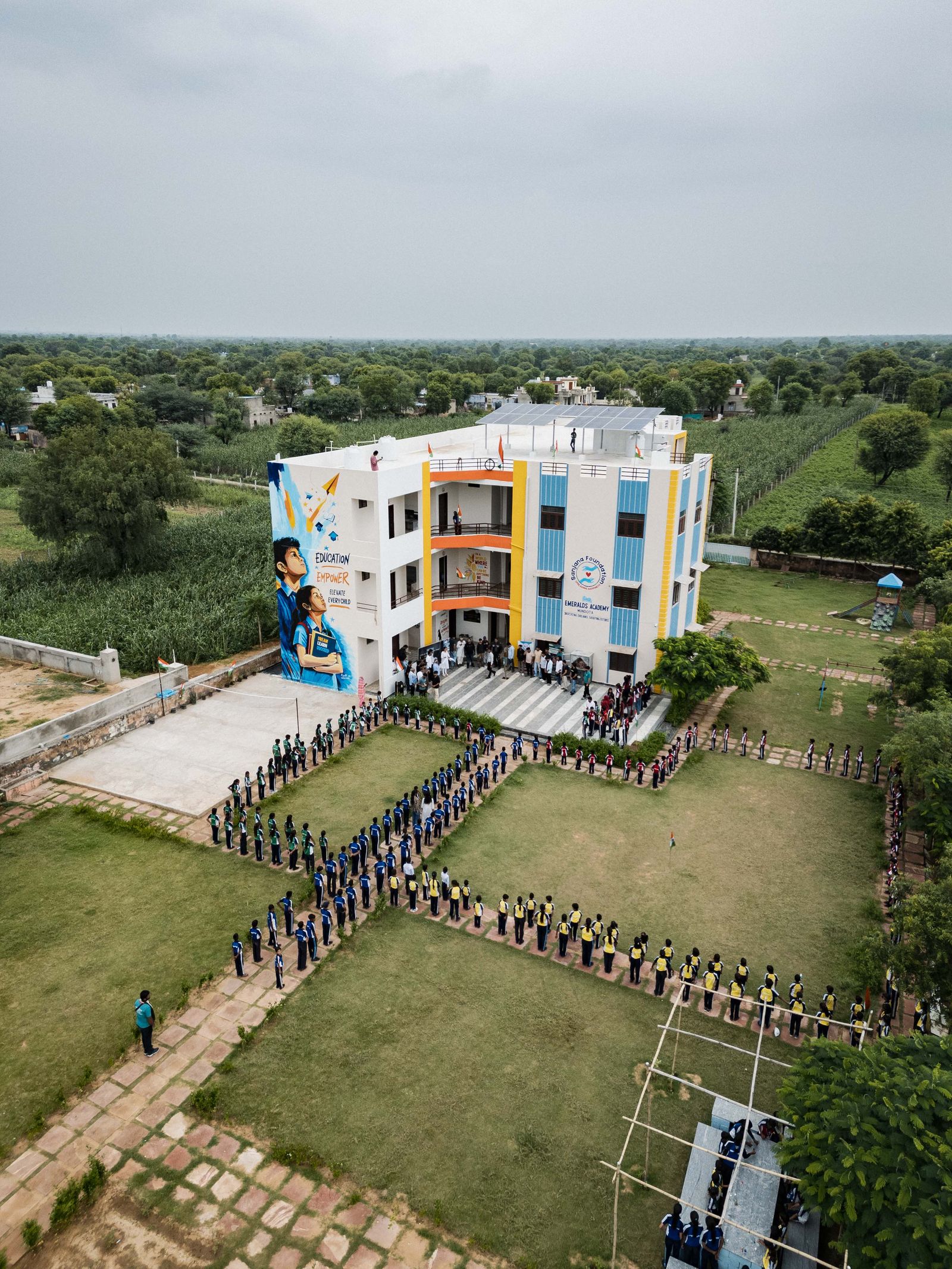 Aerial view of a colourful school building during an outdoor morning assembly