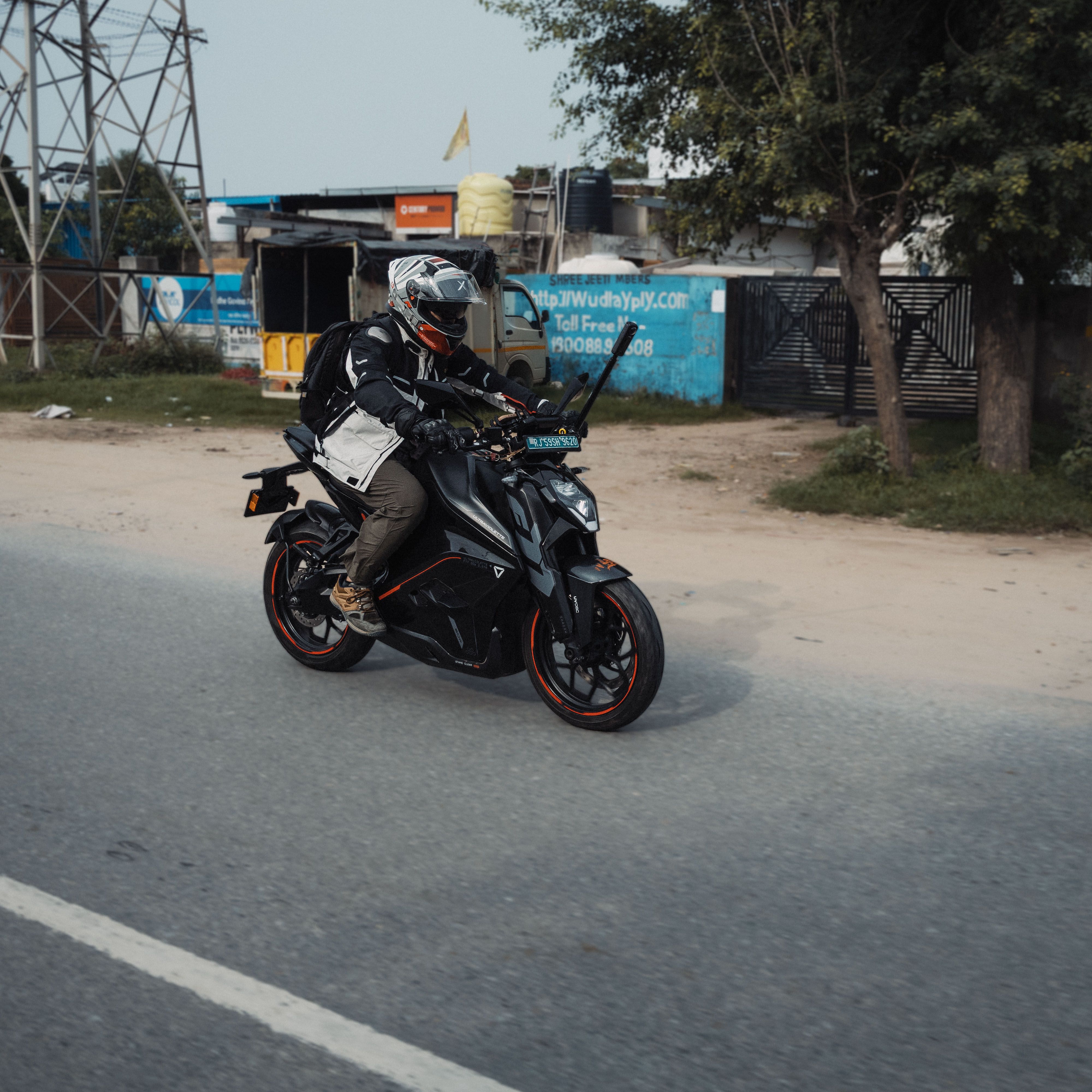 A motorcyclist rides a sleek sportbike on an open road in Jaipur, showcasing adventure and speed.