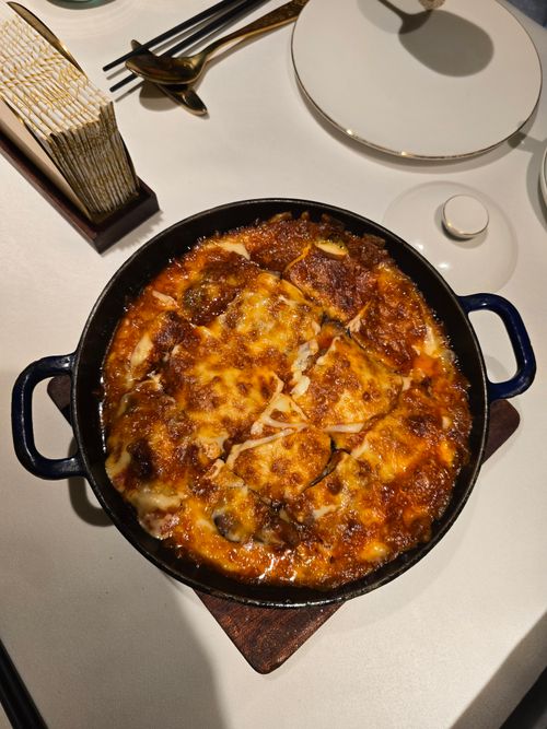Free Top view of a freshly baked cheesy eggplant dish on a dining table. Stock Photo
