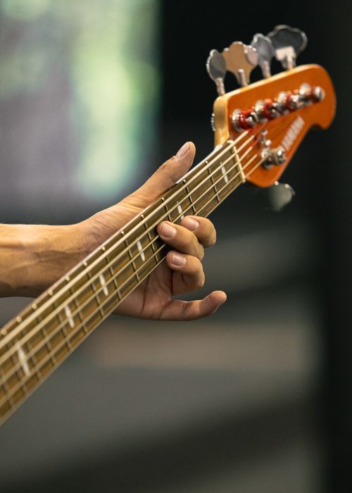 Free Detailed view of fingers playing an electric bass guitar, highlighting musical technique and artistry. Stock Photo