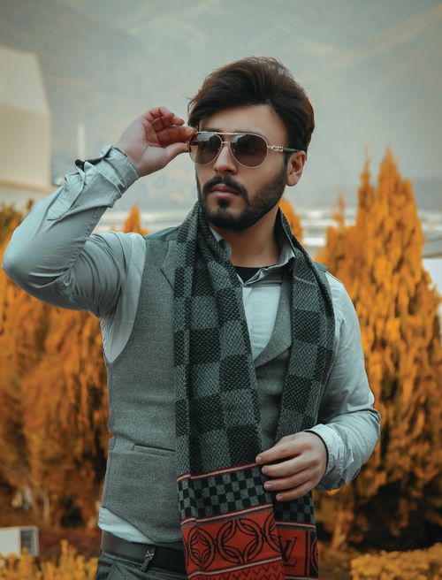 Free Fashionable man in Dubai with sunglasses and scarf in autumn setting. Stock Photo