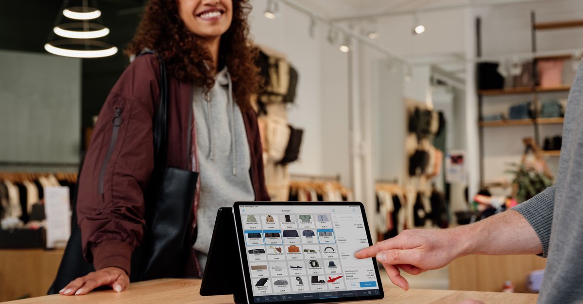Woman enjoying seamless digital checkout experience in a Berlin clothing store.