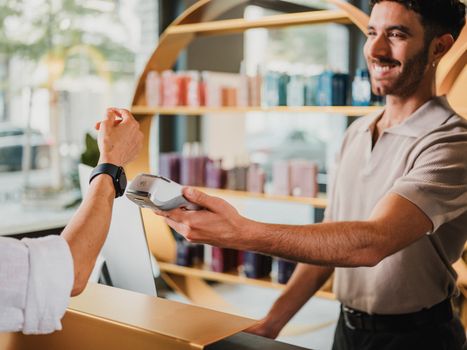 Happy customer using smartwatch for contactless payment at a Berlin retail store. Tech-savvy shopping experience.