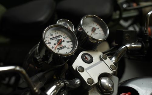 Free Detailed view of a classic motorcycle's speedometer and dashboard, capturing retro aesthetics. Stock Photo