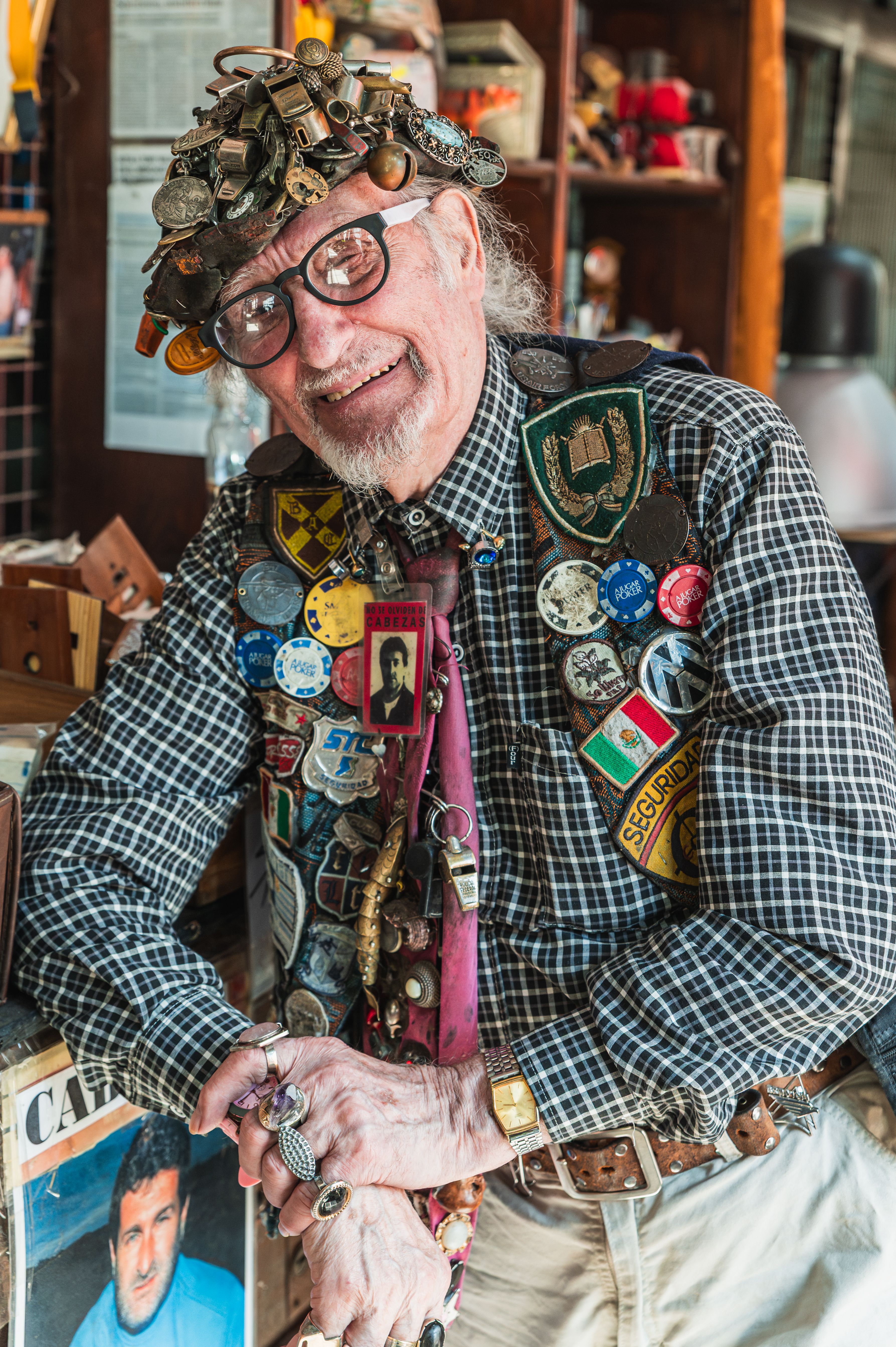 Eccentric man adorned with pins and accessories, captured at a Buenos Aires flea market.