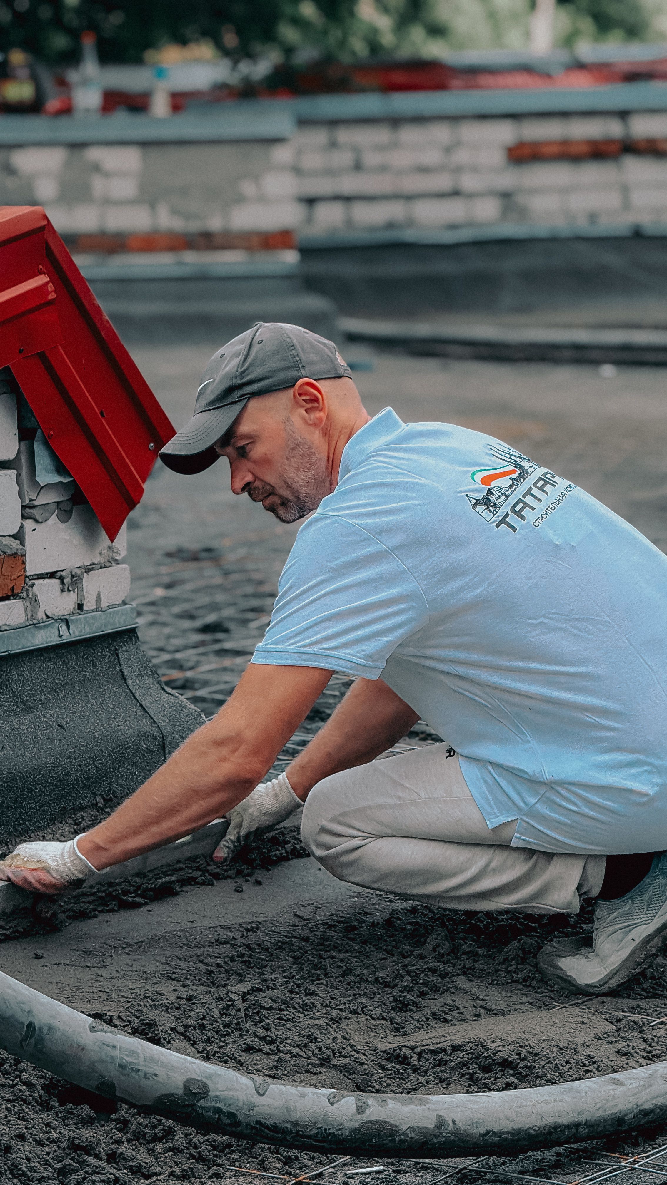 Construction worker applying tar on a rooftop with precision and skill, showcasing professional roofing techniques.