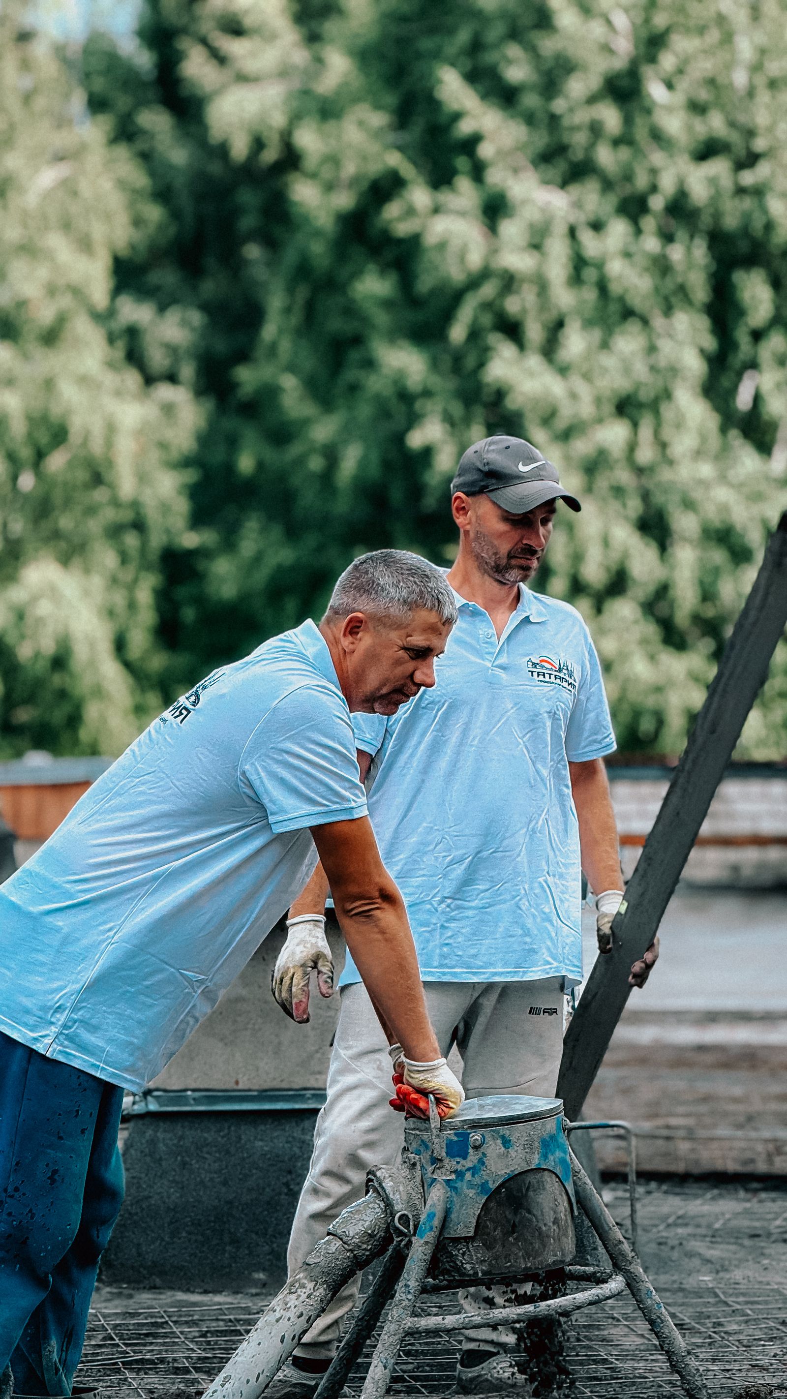 Two workers pouring and screeding a new concrete driveway (example photo)