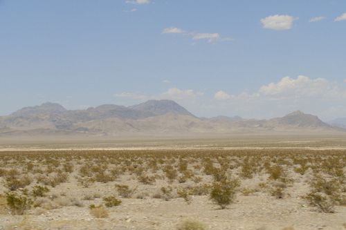 Free Expansive view of the Nevada desert with a vast mountain range under a clear blue sky. Stock Photo