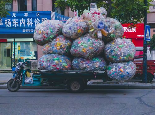 Free Urban truck loaded with large bags of plastic bottles and recyclables, street scene. Stock Photo