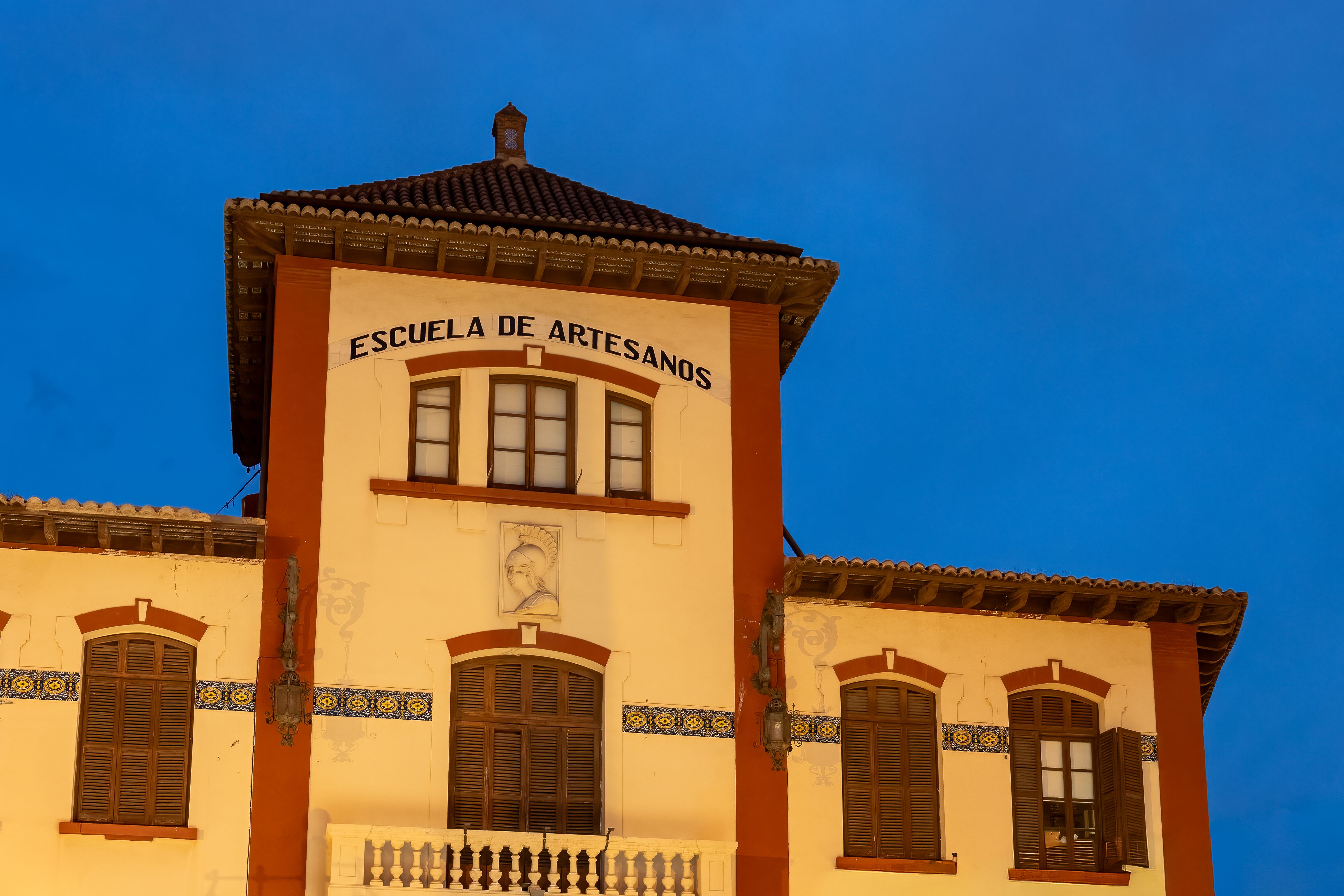 Captivating night view of the Escuela de Artesanos in Valencia with blue hour ambiance and historic architecture.