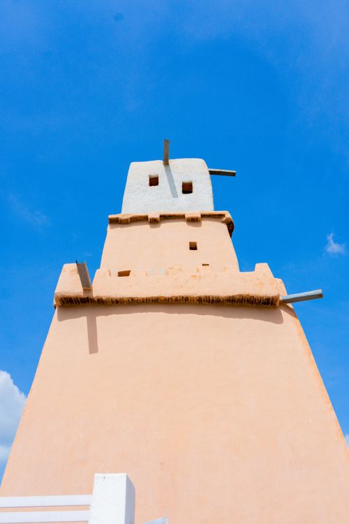 Free Adobe tower with a traditional architectural design set against a clear blue sky in Nigeria. Stock Photo