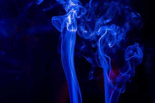Free Vibrant blue smoke swirls against a dark backdrop, creating an abstract visual effect. Stock Photo
