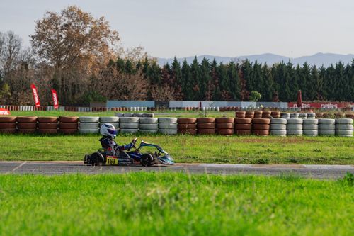 Free A go-kart racer speeds on an outdoor track surrounded by scenic nature. Stock Photo