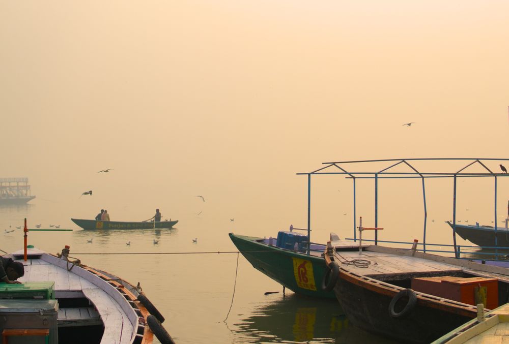 Boats resting on the Ganga at a misty sunrise in Varanasi