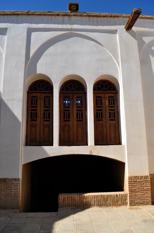 Free Close-up of Persian architecture featuring arched windows and intricate brickwork under sunlight. Stock Photo