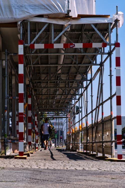 Free A view under construction scaffolding in a Berlin street during the day. Stock Photo