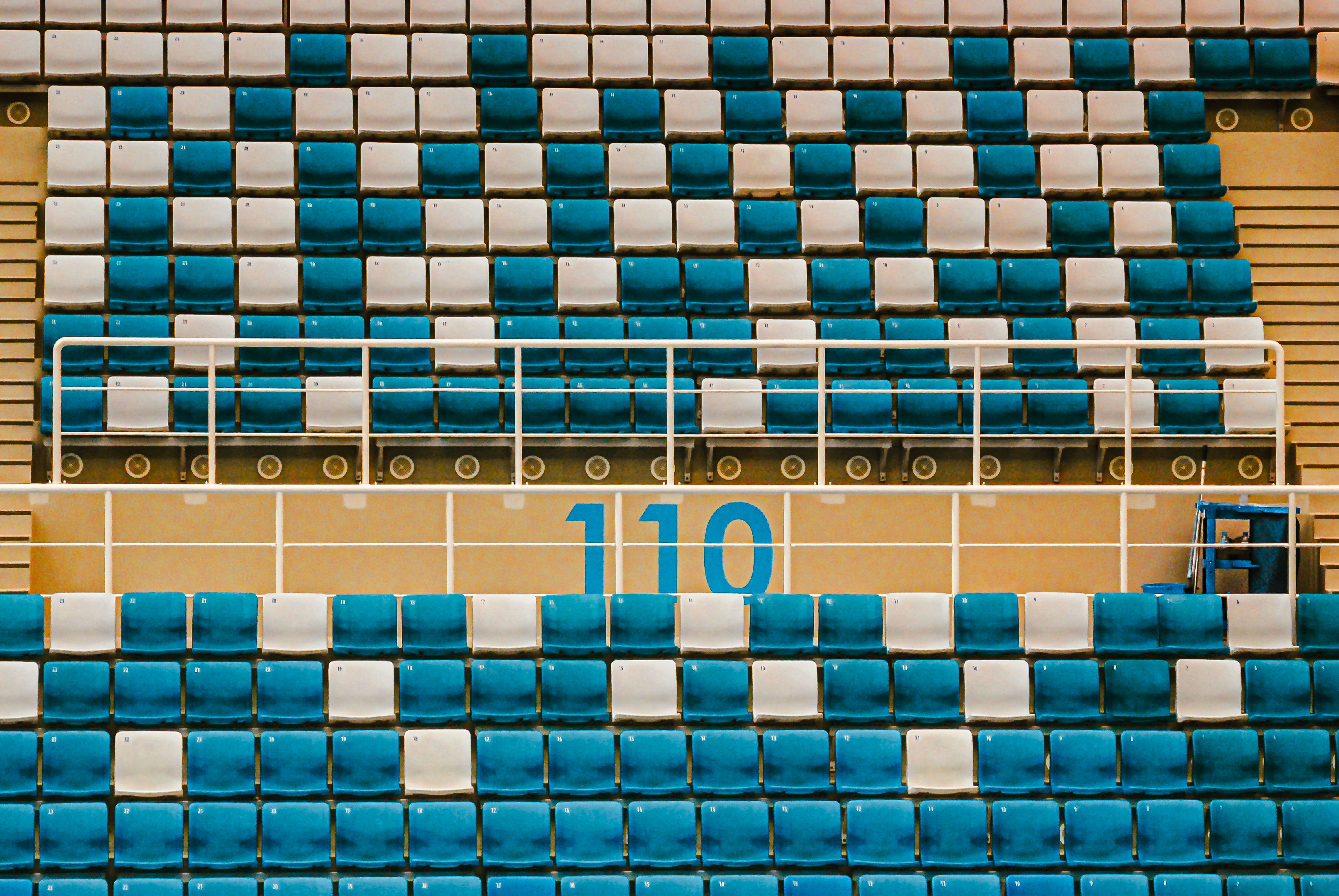 Empty stadium seats in teal and white with section number 110 visible.
