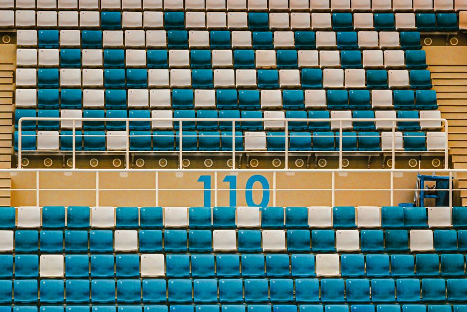 Empty stadium seats in teal and white with section number 110 visible.