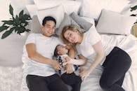 父母和宝宝一起在舒适的床上放松、欢笑