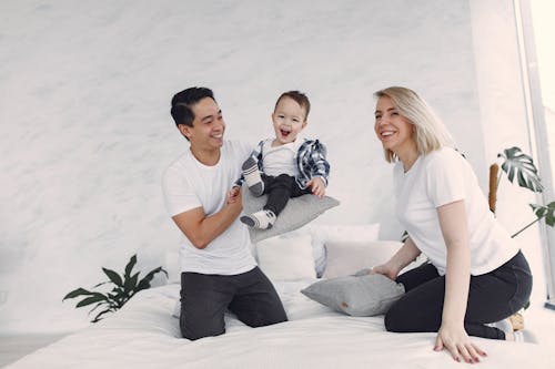 Man in White Crew Neck T-shirt Sitting Beside Woman in White T-shirt