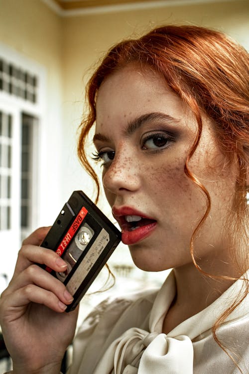 Woman Holding Black and Red Cassette Tape