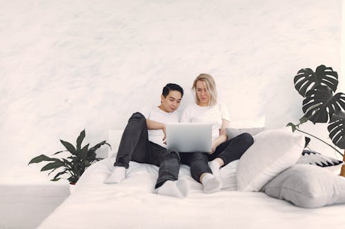 Man And Woman In White Shirt Using A Laptop