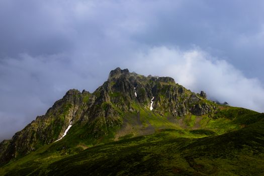 Stunning view of a rugged mountain peak with lush greenery beneath cloudy skies in Rize, Türkiye.