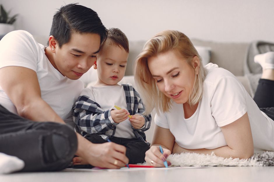 A family enjoys a fun and creative bonding session with drawing activities indoors.