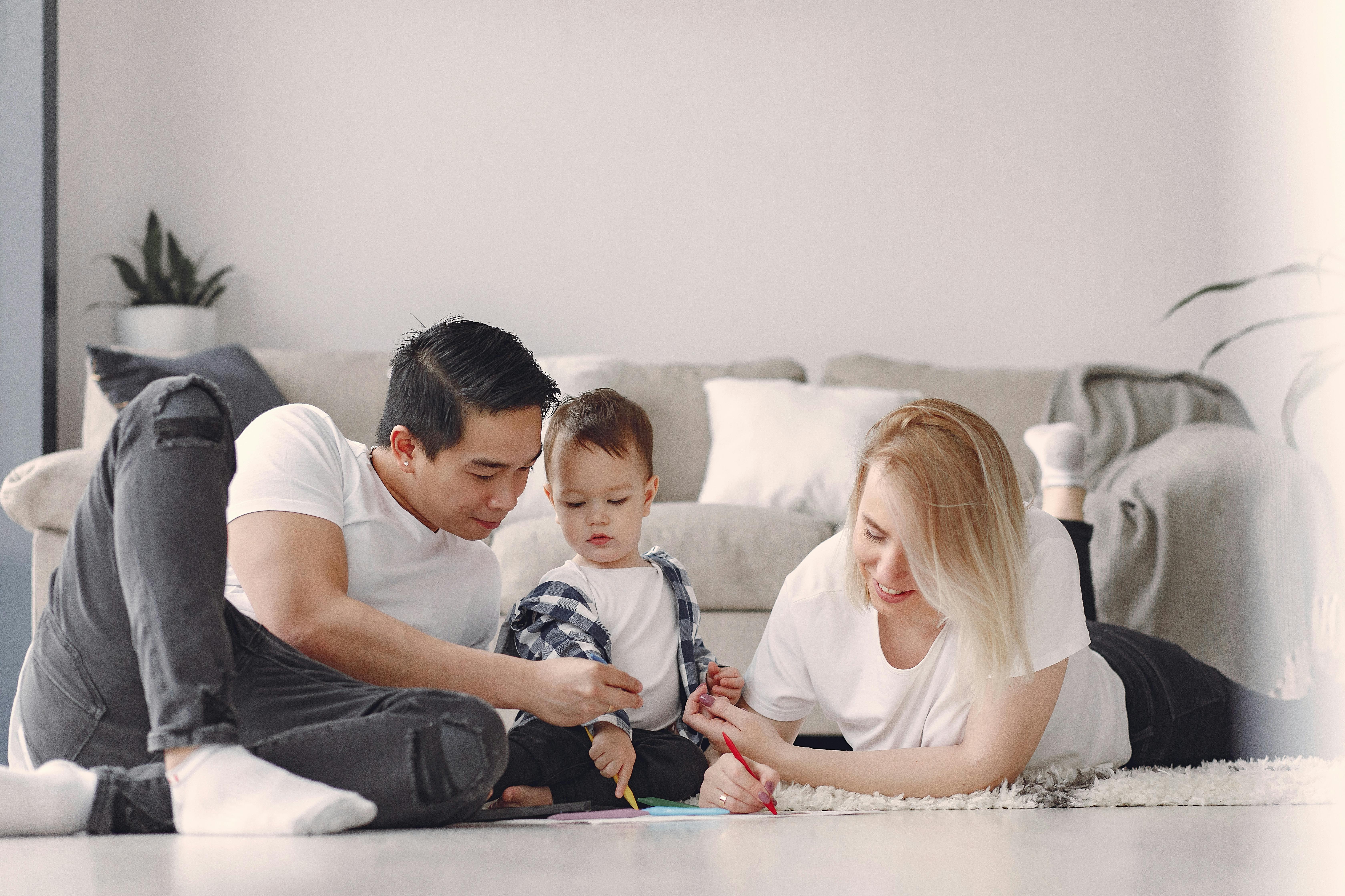 man and woman doing arts and crafts with their child