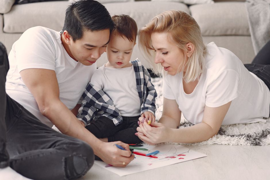 Familia amorosa creando arte juntos, fomentando el juego y la conexión en interiores.