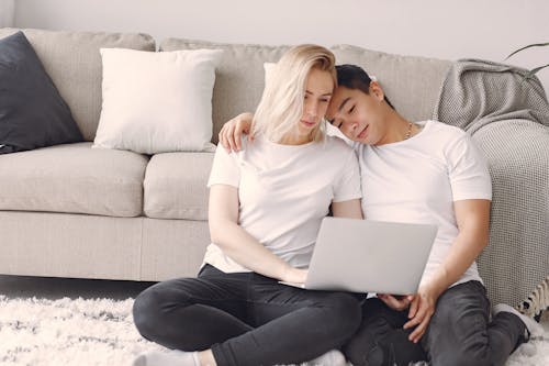Man And Woman In White Crew Neck Shirt Looking At A Laptop