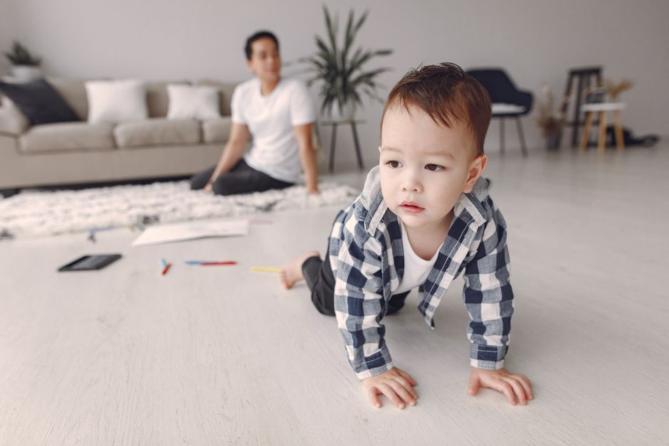 baby crawling on a mat in a living room