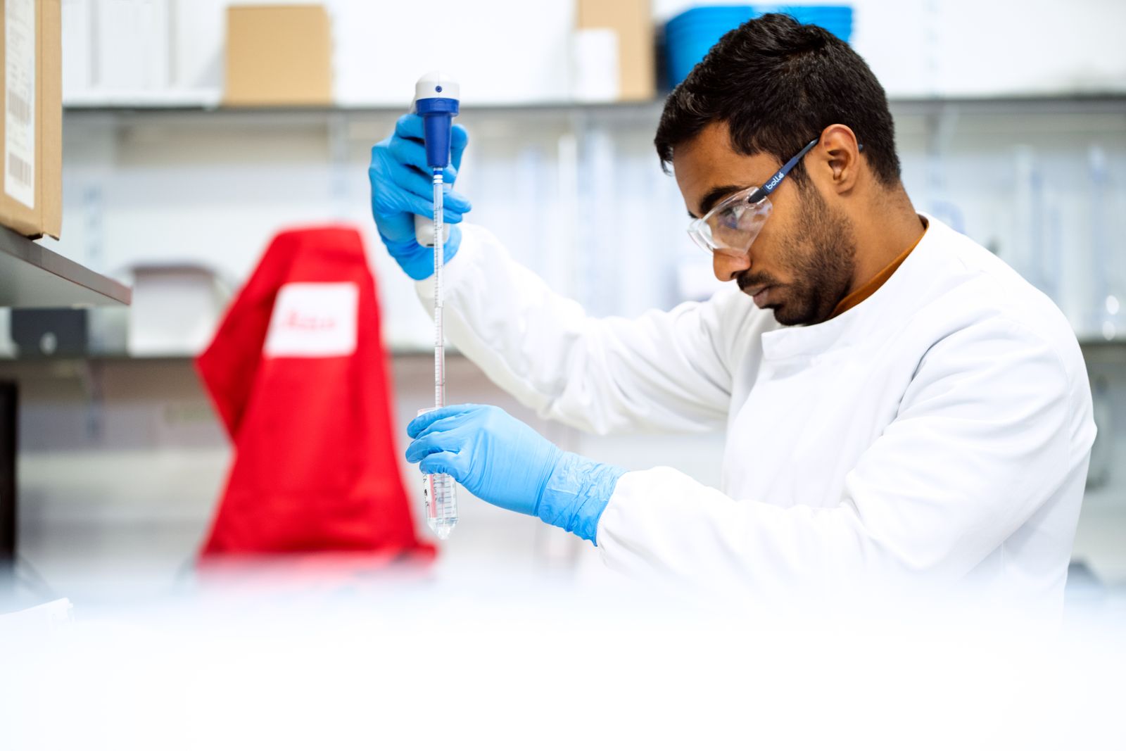 Focused scientist working with a pipette in a clean laboratory environment